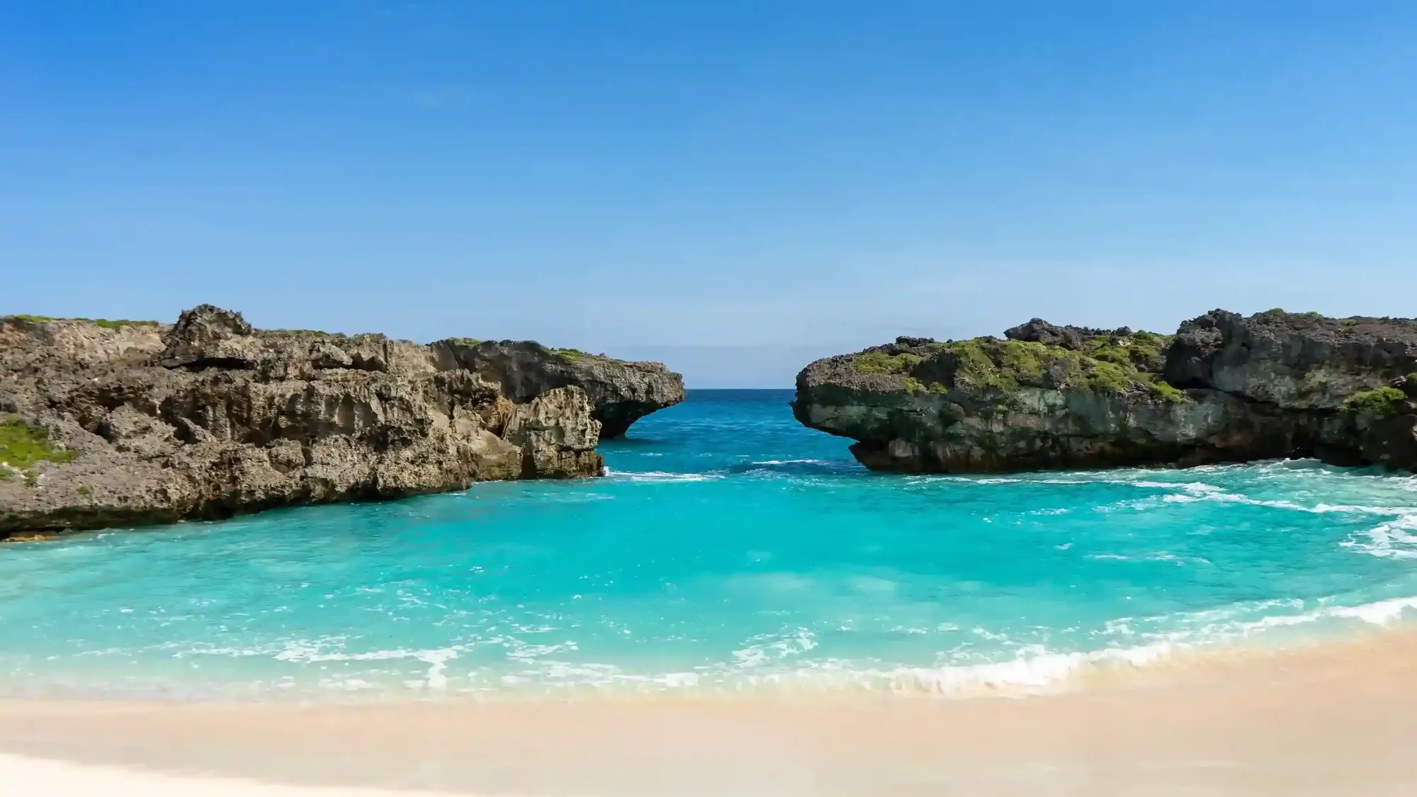 Turquoise cove between rock headlands at Mandorak Beach, Sumba