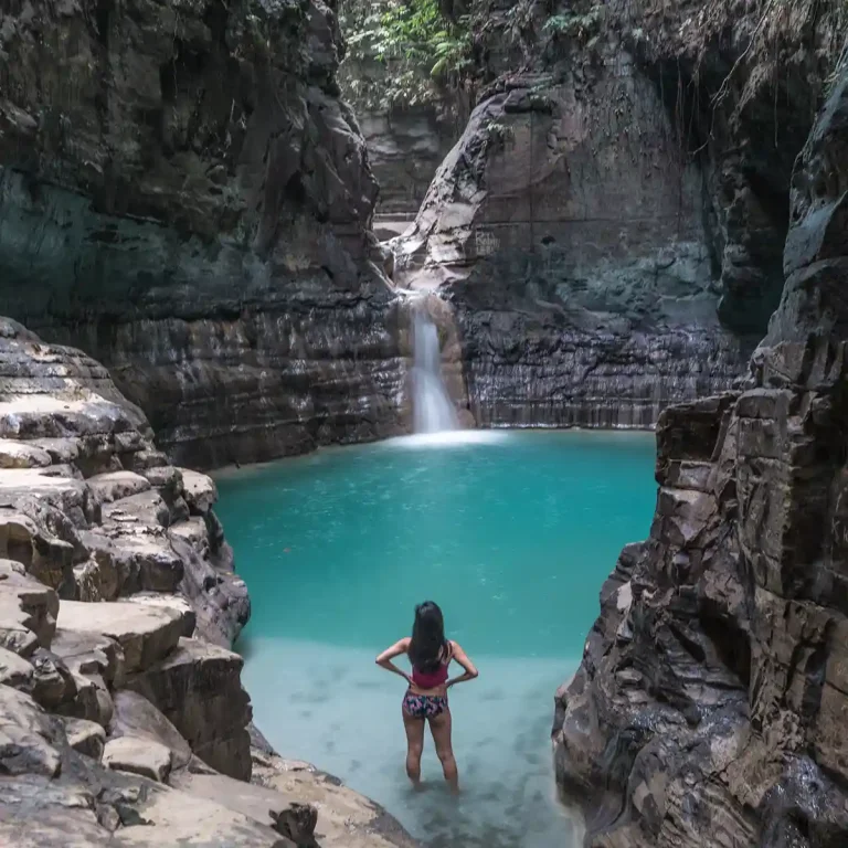 Traveller at the emerald pool of Waimarang waterfall, East Sumba