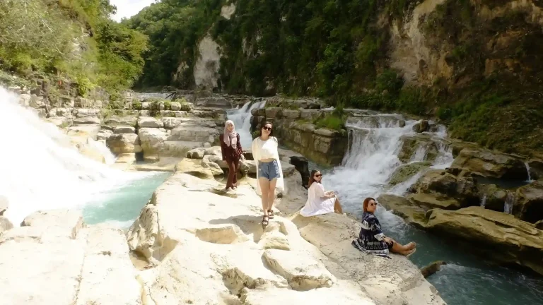 Travellers relaxing at a limestone waterfall in Sumba