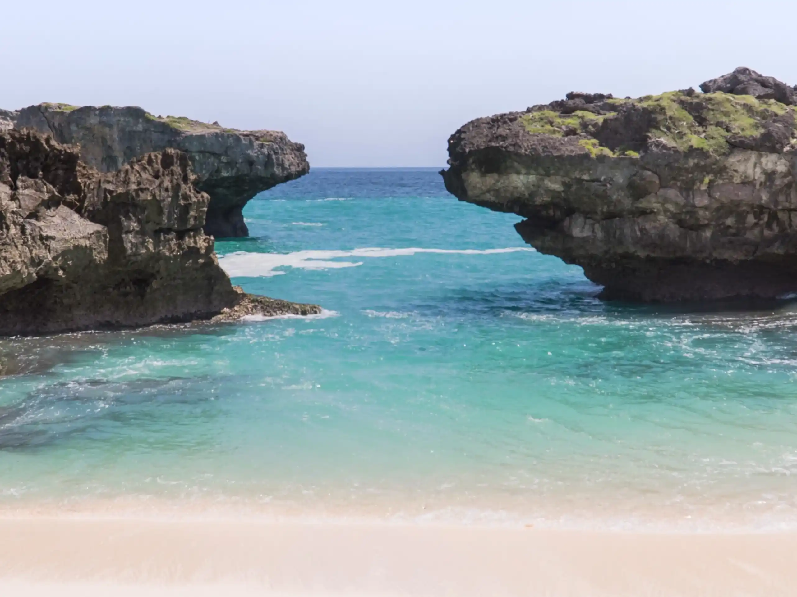 Turquoise cove between the rock cliffs of Mandorak Beach, Southwest Sumba